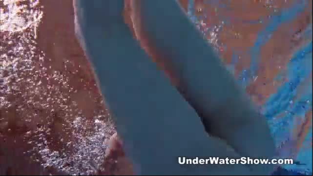 Redheaded cutie swimming nude in the pool